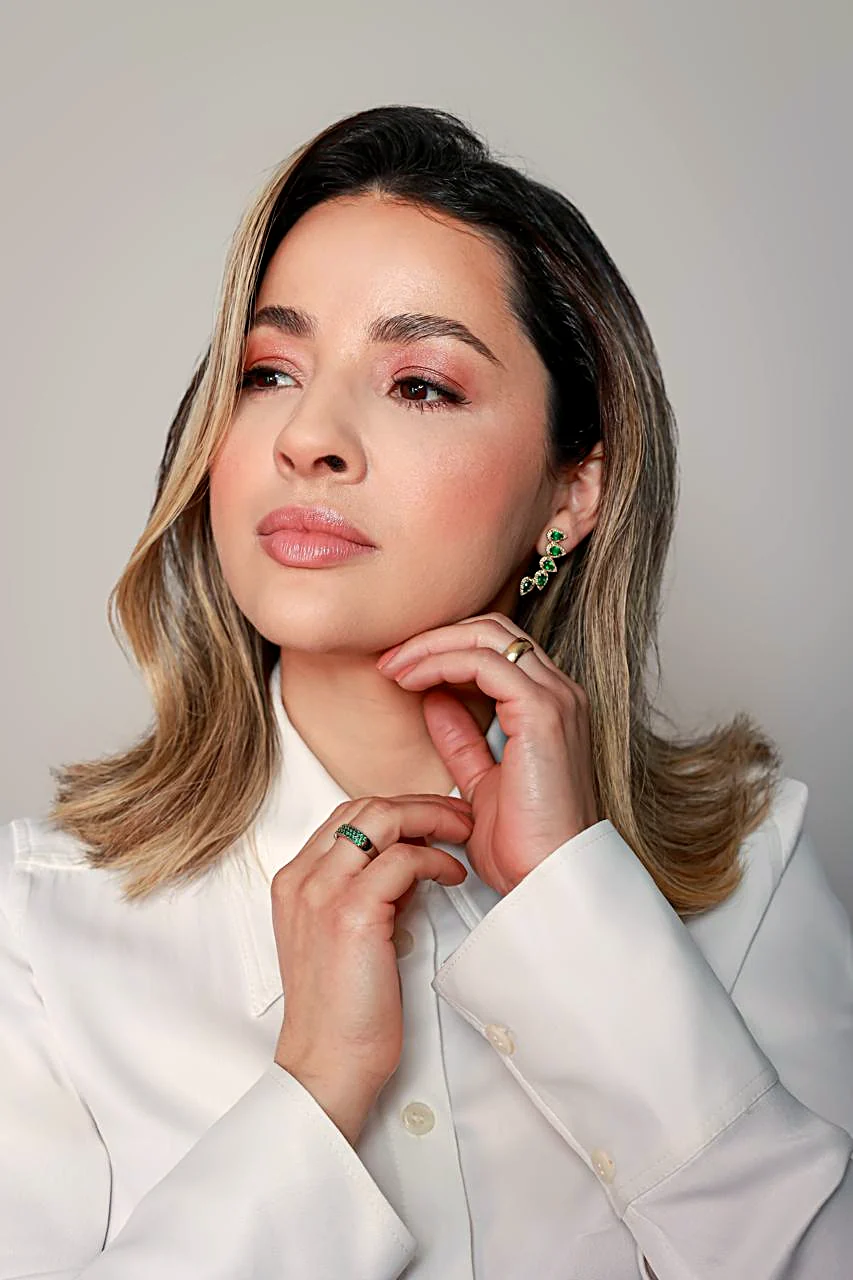 Retrato da Dra. Luciane Lopes de perfil, olhando para o lado, com a mão sob o queixo